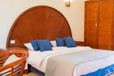 a bedroom with a large bed with a wooden headboard at Cozy Studio 1st Avenue South Side in Hurghada