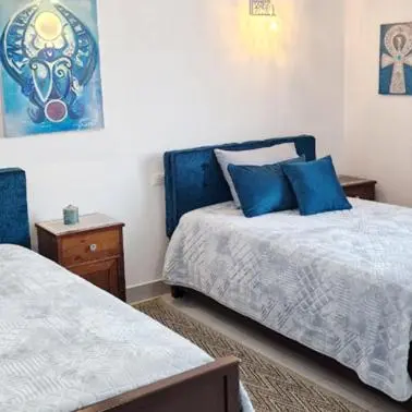 a bedroom with two beds with blue pillows at Hurghada mit Charme in Hurghada