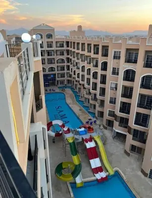 a large apartment complex with a pool and a water slide at الغردقه in Hurghada