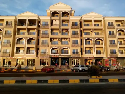 a large building with cars parked in front of it at Hurghadiansrealty in Hurghada