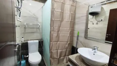 a bathroom with a white toilet and a sink at Stylish Sunny Central 1BR Apartment Hurghada in Hurghada