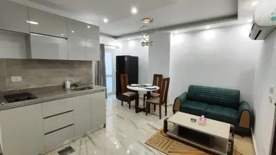a kitchen and a living room with a couch and a table at Stylish Sunny Central 1BR Apartment Hurghada in Hurghada