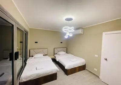 a room with two beds and a chandelier at Apartment 3 Bedrooms Bali BR C1-D with Private Pool at Bali in Hurghada
