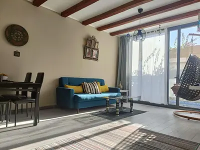 a living room with a blue couch and a table at Bali-Style 1BR 10 Min 2 Downtown in Hurghada