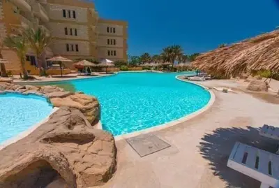 a large swimming pool next to a building at Palma Resort A155 Chalet Hurghada in Hurghada