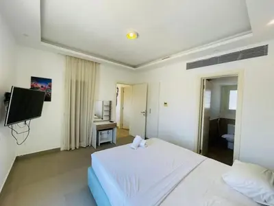a bedroom with a white bed and a television at Luxury villa in gouna in Hurghada