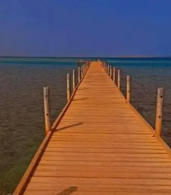 a wooden pier stretches out into the water at Fox Beach Inn in Hurghada