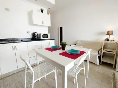 a white kitchen with a white table and chairs at Tranquil escape in Hurghada