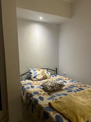 a bed with two pillows on it in a room at Cozy Studio on Sheraton Road near Metro Market in Hurghada