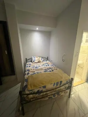 a small bed in a white room with a bed frame at Cozy Studio on Sheraton Road near Metro Market in Hurghada