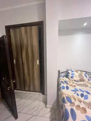a bedroom with a bed and a wooden door at Cozy Studio on Sheraton Road near Metro Market in Hurghada