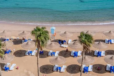 an aerial view of a beach with chairs and umbrellas at Strandapartment mit Meerblick & Pool im Juliana Beach Resort, Hurghada in Hurghada