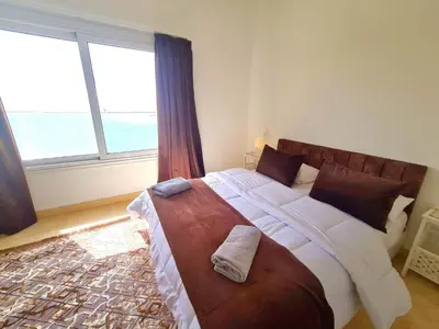 a bedroom with a large bed with a large window at White villa in Hurghada