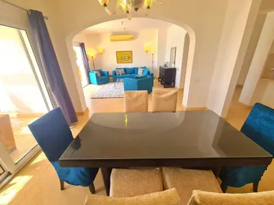 a dining table and chairs in a living room at White villa in Hurghada