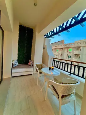 a room with a balcony with a table and chairs at Hurghada Stylish Heaven Luxury Apartment in Hurghada