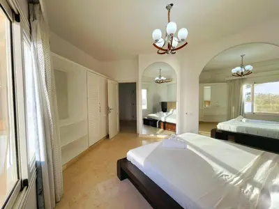 a bedroom with two beds and a large mirror at 5 bedroom villa with private pool at el gouna in Hurghada