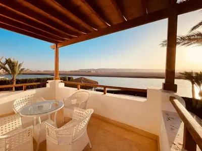 a balcony with a table and chairs overlooking the ocean at 5 bedroom villa with private pool at el gouna in Hurghada