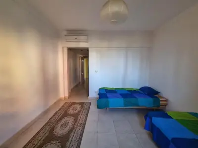 a bedroom with two beds and a rug in it at Esplanadа Apartments in Hurghada