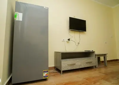 a room with a refrigerator and a tv on a wall at Florenze Khamsin Hurghada in Hurghada