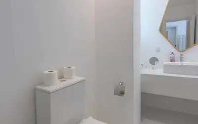 a bathroom with a sink and a toilet and a mirror at Relax in Style I Lagoon-Front 2BR in Swan Lake El Gouna in Hurghada