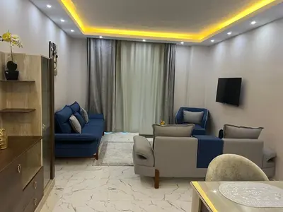 a living room with a blue couch and chairs at Hurghada Fanadir Bay in Hurghada