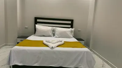 a bed with two towels in the shape of a heart at Prestige Residency in Hurghada