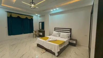 a bedroom with a bed and a desk in it at Prestige Residency in Hurghada