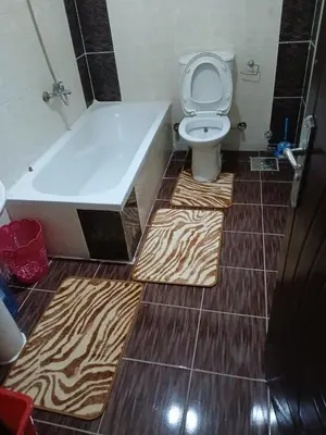 a bathroom with a zebra patterned flooring and a toilet and tub at H&H Twin Apartment in Hurghada