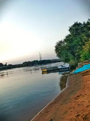 a body of water with boats on the shore at Fox Nubian Hotel in Aswan