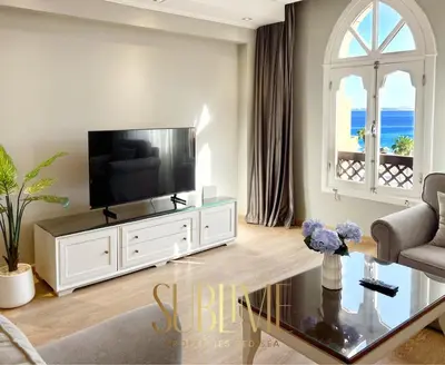 a living room with a television on a white entertainment center at Tawaya 1br with sea view in Hurghada