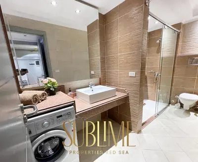 a bathroom with a sink and a washing machine at Tawaya 1br with sea view in Hurghada