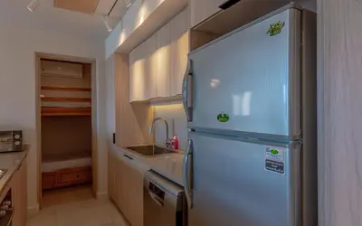 a small kitchen with a refrigerator and a sink at Relaxing 3BR Fanadir Marina Home l El Gouna Red Sea l Lagoon Views in Hurghada