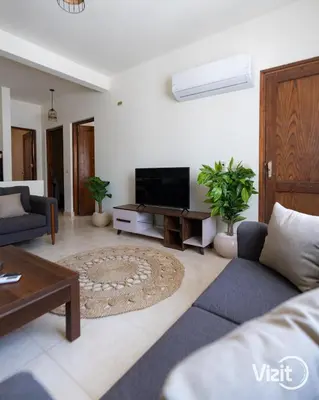 a living room with a couch and a tv at Stylish flat with terrace in Hurghada