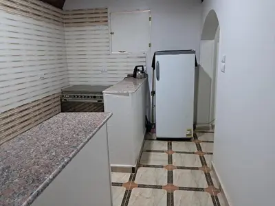 a kitchen with a refrigerator and a tile floor at Makky ka in Jazīrat Suhayl