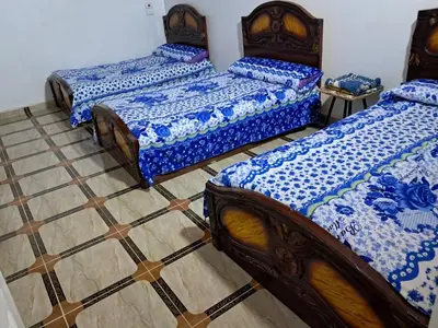 three beds sitting in a room with a tile floor at Makky ka in Jazīrat Suhayl
