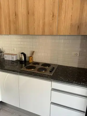 a kitchen with a stove and white cabinets at 2 BR with a small private pool in Hurghada