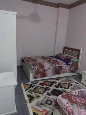 a bedroom with two beds and a rug on the floor at شقة فاخرة خلف الاستاد اسوان in Aswan