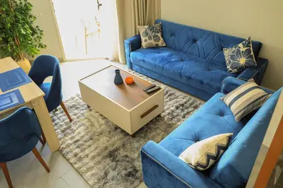 a living room with a blue couch and a table at Angeli Apartment Scandic Rezort in Hurghada