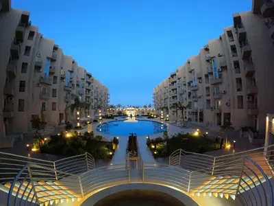 a large pool in a courtyard between two buildings at Hurghada Princess resort, Private Sandy Beach & 3 Pools in Hurghada