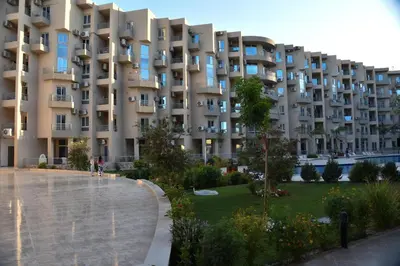 a large apartment building with a park in front of it at Hurghada Princess resort, Private Sandy Beach & 3 Pools in Hurghada