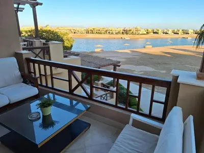 a balcony with a view of a body of water at Bella Sabina, Lovely one bedroom chalet with pool in Hurghada