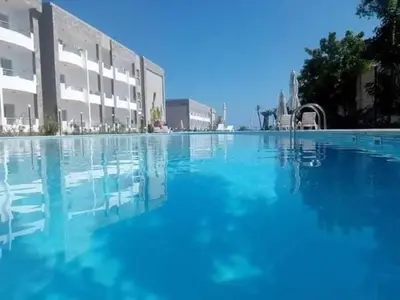 a large pool of blue water in front of a building at Lovely APT Sunny Beach Front, Near Senzo Mall Free WIFI in Hurghada