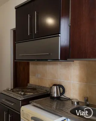 a kitchen with a stove top oven and cabinets at Cosy flat in Makadi heights in Hurghada