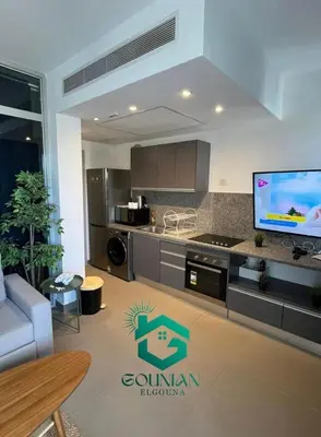a living room with a kitchen with a tv in it at Sholan, 1 Bedroom, Ground floor in Hurghada