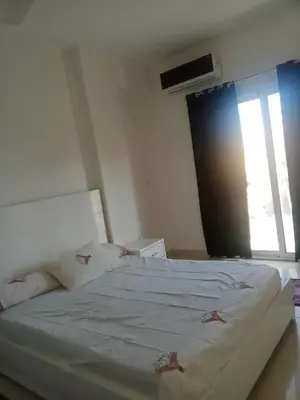 a large white bed in a room with a window at elomda in Luxor