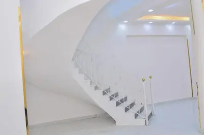 a staircase in a white room with a door at Jasmin house in ‘Ezbet Abu Ḥabashi