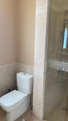 a bathroom with a white toilet and a shower at SunShine Joubal view in Hurghada