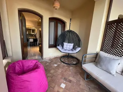 a living room with a chair and a swing at SunShine Y1-0-6 in Hurghada