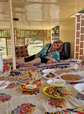 a woman sitting at a table with plates of food at Nile Bride Felucca in Aswan
