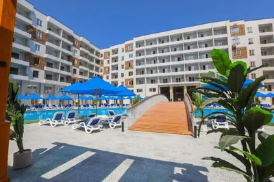 a large hotel with chairs and a swimming pool at Tiba Golden Resort in Hurghada